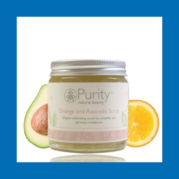 A Jar of Orange and Avocado Scrub set on a white background with half an avocado and a slice of orange